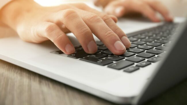 Businessman using laptop, close up
