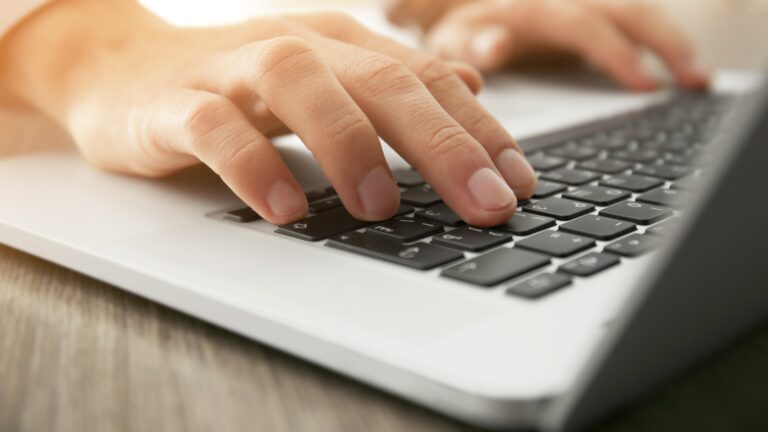Businessman using laptop, close up