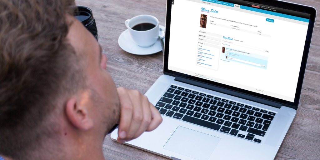 En man som sitter och använder TimeBook, vårt företagsinterna sociala forum.