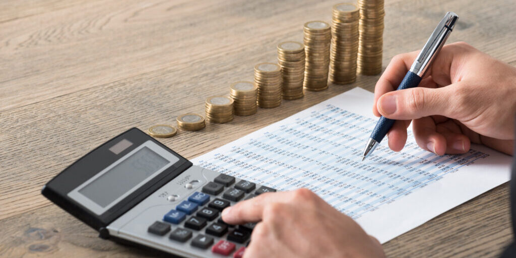Close-up Of A Businessman Analyzing Financial Report man i kostym som räknar på sina timmar och kostnader