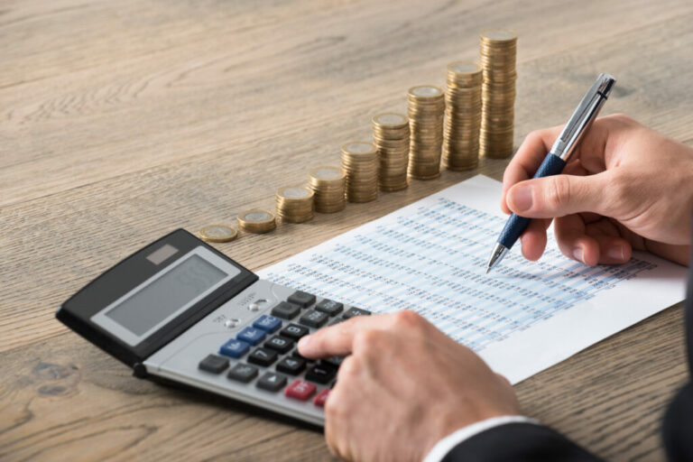 Close-up Of A Businessman Analyzing Financial Report man i kostym som räknar på sina timmar och kostnader