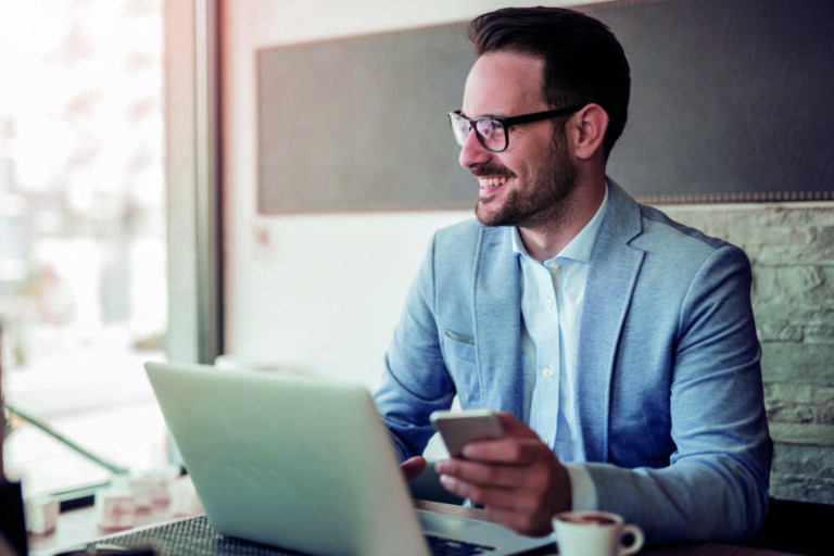 Young businessman working in office, sitting at desk. Businessman och entreprenör