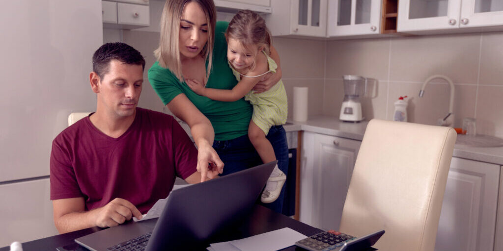 Worried parent calculating bills at home