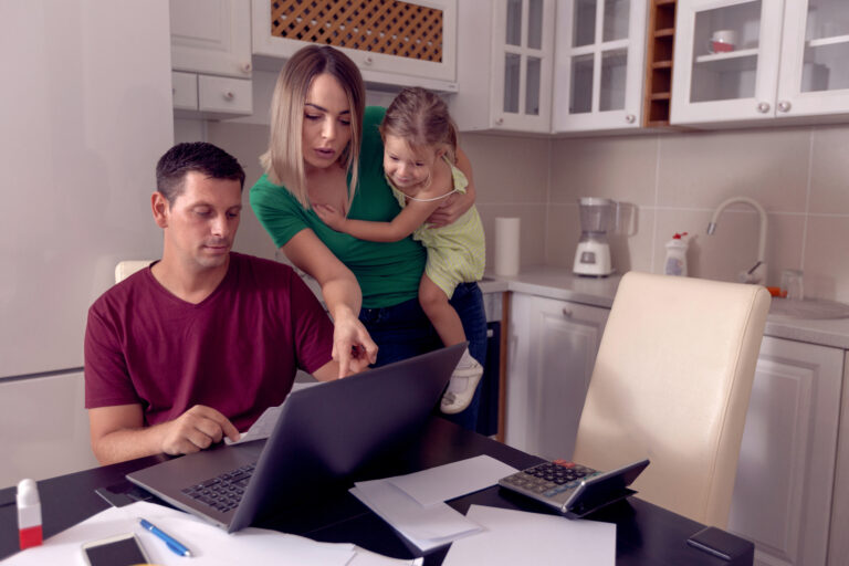 Worried parent calculating bills at home