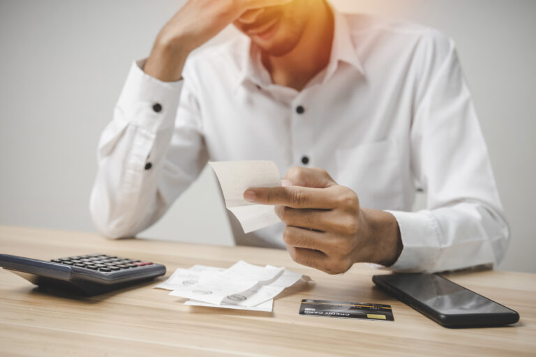 stressed young male upset and worried about credit card and fami En man som tittar på sina kvitton och räknar på sina utlägg