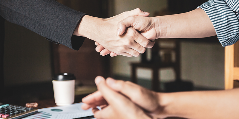 Personer som skakar hand, illustrerande att ett avtal slut.